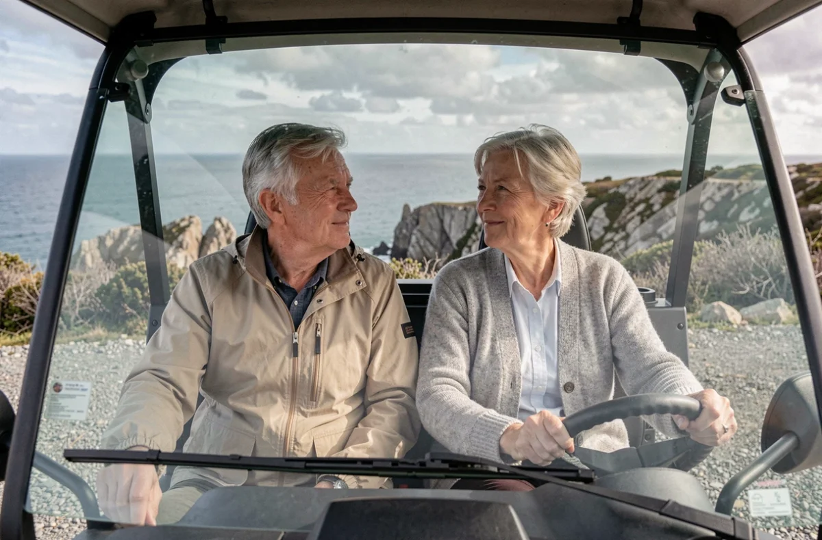 Couple de seniors dans une voiture sans permis face au panorama d'une côte atlantique française