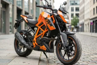 KTM Duke 125 2026 en ville garée sur un trottoir urbain européen, vue 3/4 avant mettant en valeur son design agressif et son cadre treillis orange