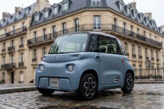 Voiture sans permis compacte garée sur un trottoir urbain parisien, vue de face en trois quarts