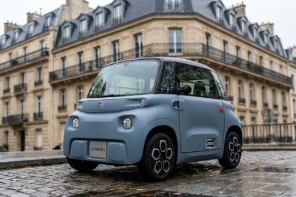 Voiture sans permis compacte garée sur un trottoir urbain parisien, vue de face en trois quarts