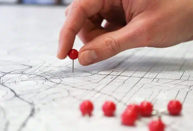 person holding red round medication pill